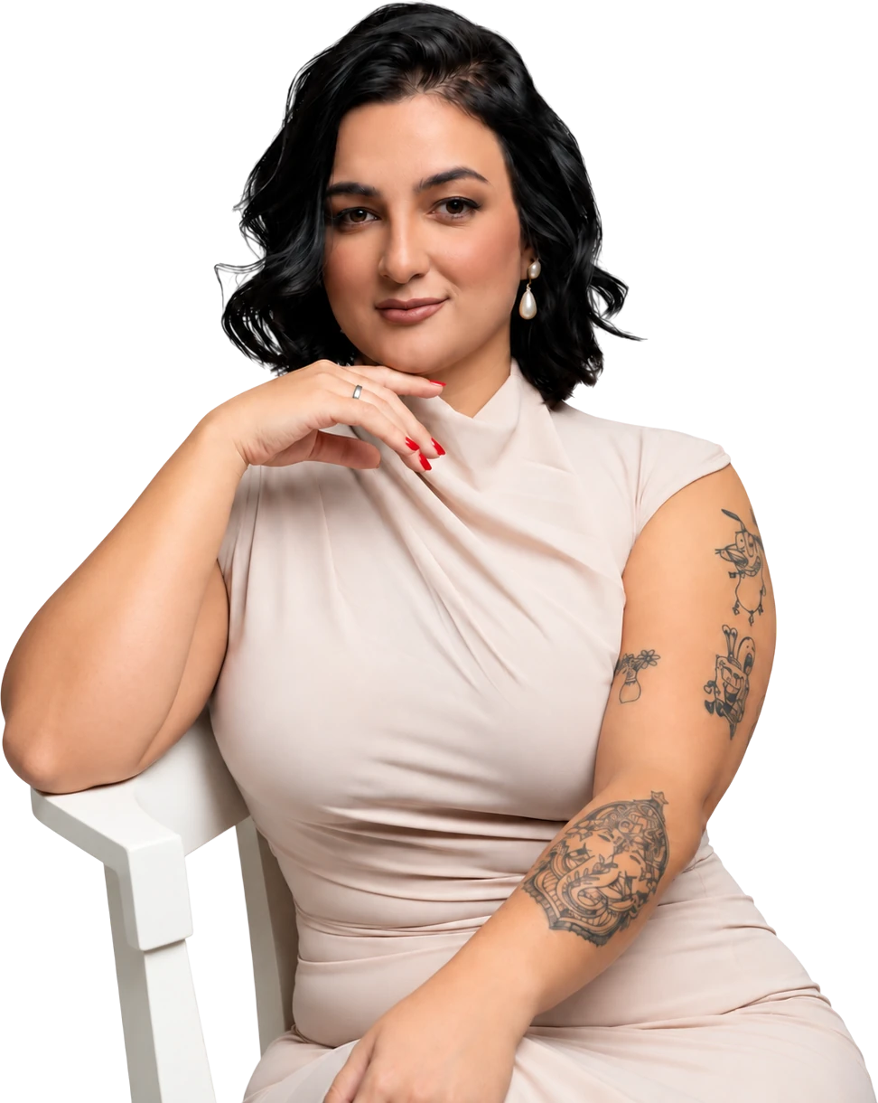 Luana Cabral, sentada com a mão apoiada no queixo, vestindo blazer branco